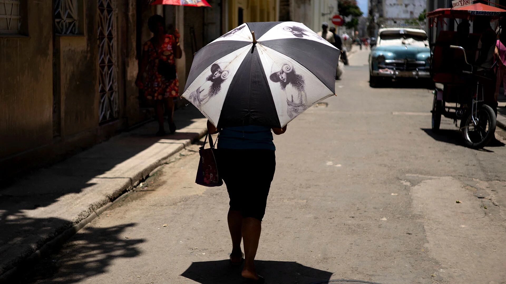 Una peatona se protege con un paraguas en La Habana, Cuba, el miércoles 5 de julio de 2023. El planeta entero se sofocó durante los dos días no oficiales más calurosos registrados por humanos el lunes y el martes, según científicos de la Universidad de Maine en el proyecto Climate Reanalyzer. (Foto AP/Ramón Espinosa)

