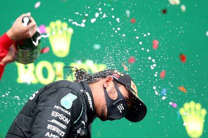 Formula One F1 - Turkish Grand Prix - Istanbul Park, Istanbul, Turkey - November 15, 2020 Mercedes' Lewis Hamilton celebrates on the podium with sparkling wine after winning the race alongside third placed Ferrari's Sebastian Vettel Pool via REUTERS/Tolga Bozoglu