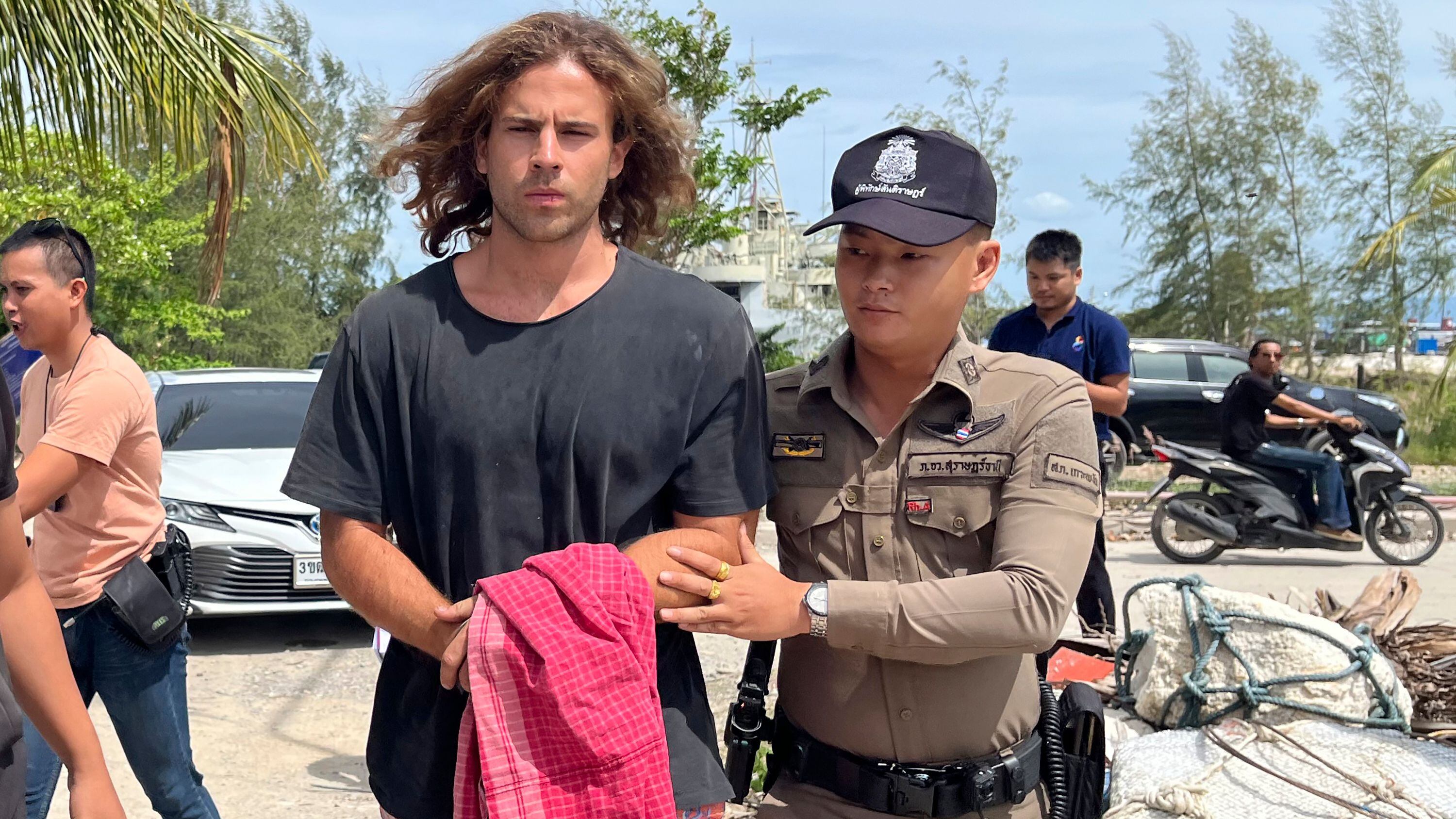 En esta imagen de archivo, un agente de la policía tailandesa escolta a Daniel Sancho Bronchalo, un ciudadano español sospechoso de asesinar y descuartizar a un cirujano colombiano, desde la isla de Koh Phagnan al tribunal de la isla Koh Samui, en el sur de Tailandia, el 7 de agosto de 2023. (AP Foto/Somkeat Ruksaman, archivo)