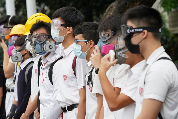 Resultado de imagen para En el primer dÃ­a del curso el lunes, los estudiantes de secundaria en Hong Kong complementaron sus formales uniformes blancos con mÃ¡scaras de gas, gafas protectoras y cascos, en una jornada de huelgas que pretendÃ­a mostrar el compromiso con el movimiento de protestas contra el gobierno.