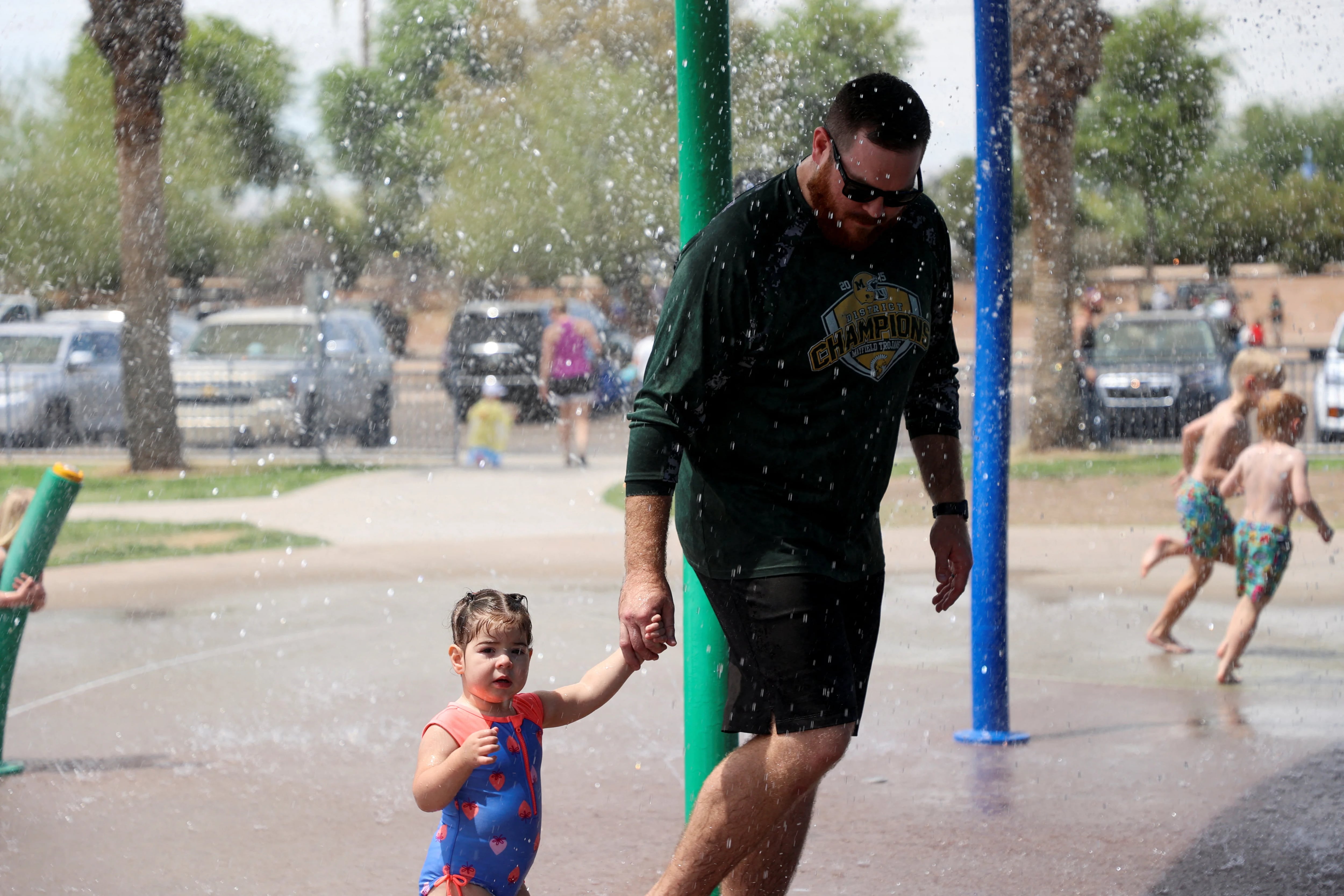 Una niña y su padre se refrescan en un parque acuático en Phoenix (REUTERS/Liliana Salgado)