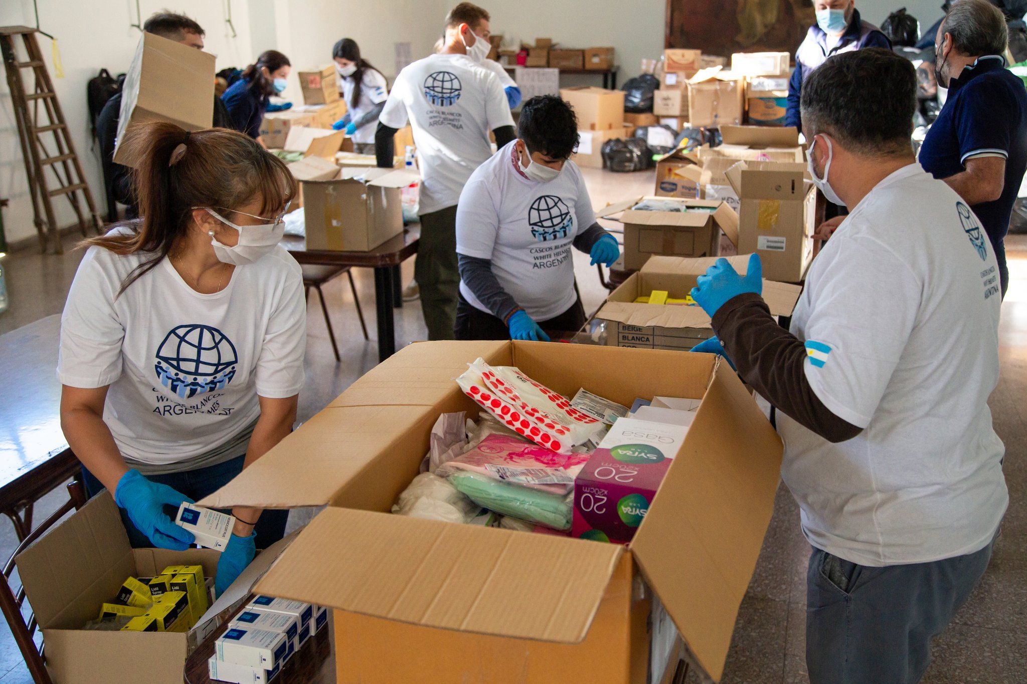 Cascos Blancos trabajando en el armado de las cajas que se enviarán a Cuba con insumos sanitarios