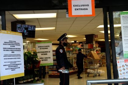 Fotografía fechada el 13 de abril del 2020, que muestra a personal de seguridad vigilando centros comerciales en Ciudad de México (México). Persianas bajadas, puertas tapiadas y el doble de guardias de seguridad y policías es el panorama que deja la pandemia de COVID-19 Foto: EFE/Sáshenka Gutiérrez 