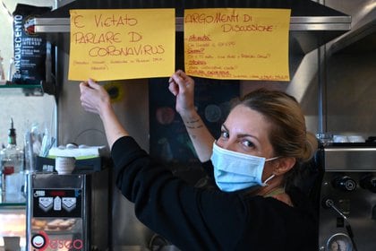 "Está prohibido hablar del coronavirus", ve un cartel en el bar Feeling de Roma, que indica a su dueña, Cristina Mattioli (Foto de Alberto PIZZOLI / AFP)