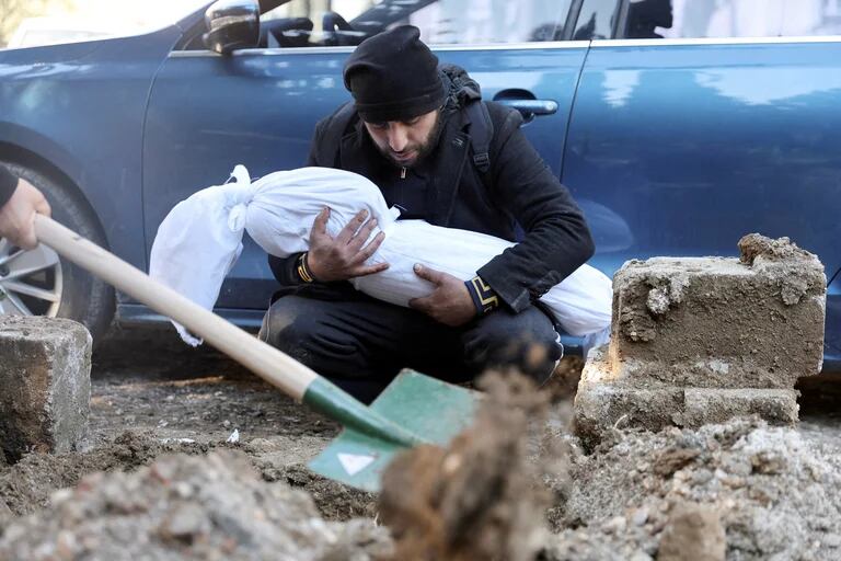 Murad Muhiddin lleva el cuerpo de su hijo de 2 años, Vail, víctima de un edificio derrumbado en la provincia de Hatay, T 