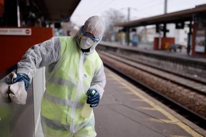 Un trabajador limpia con desinfectante una estación de tren en Francia (Reuters)