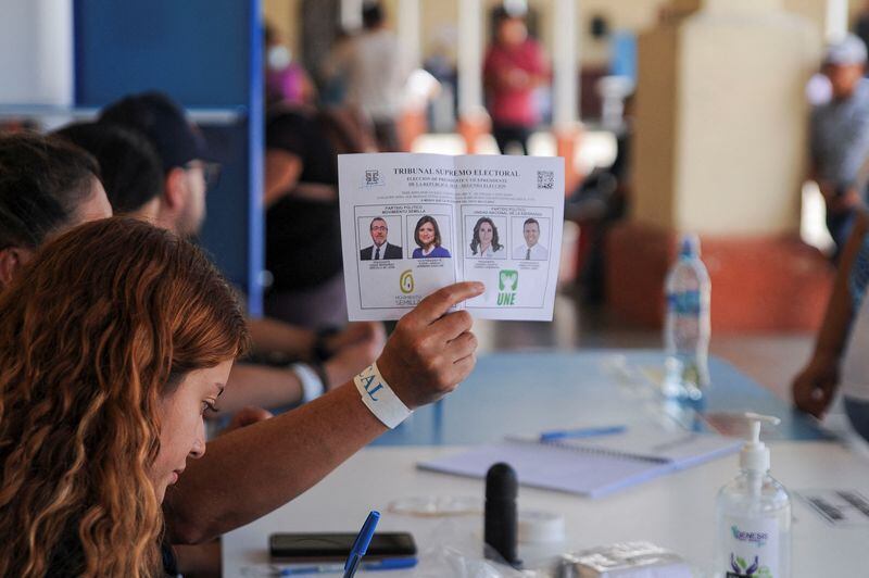 Un miembro de mesa muestra una boleta en un colegio electoral  (REUTERS/Cristina Chiquin)