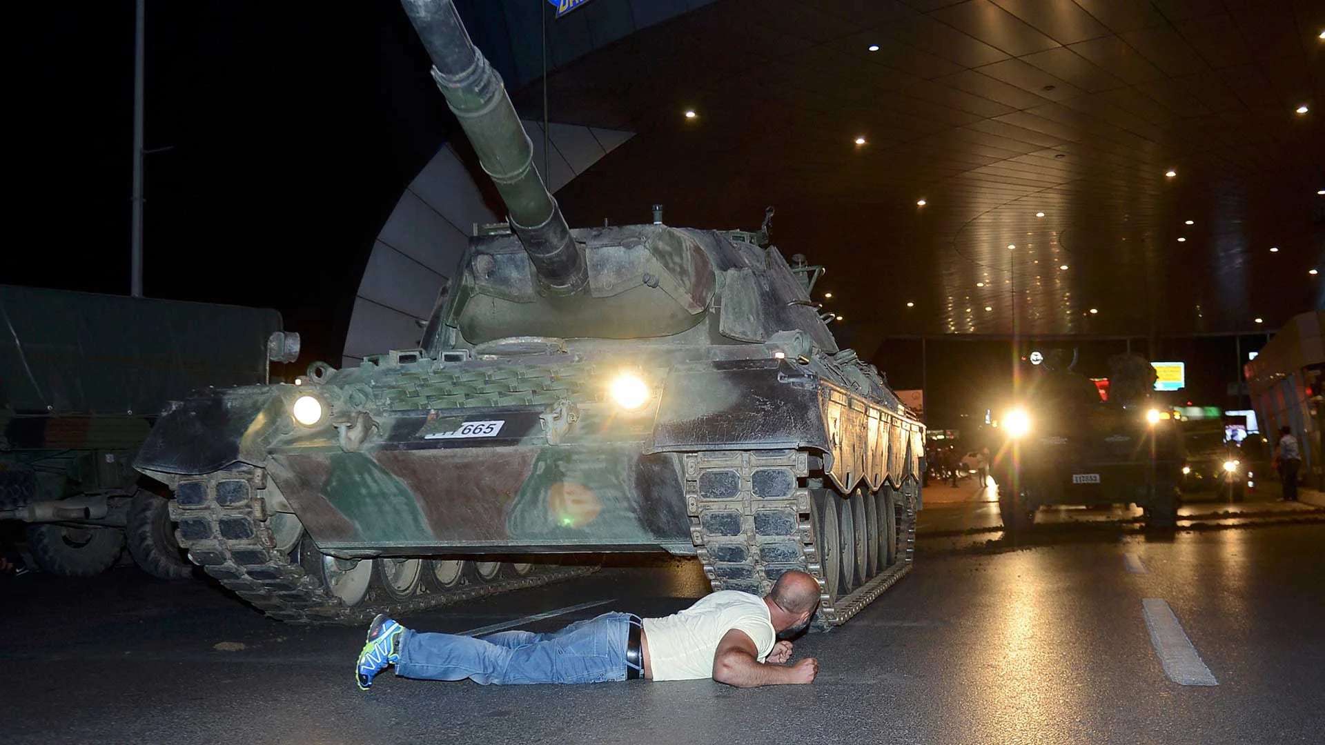 Un ciudadano se arrojó debajo de un tanque para evitar que éste continuara avanzando. (Reuters)