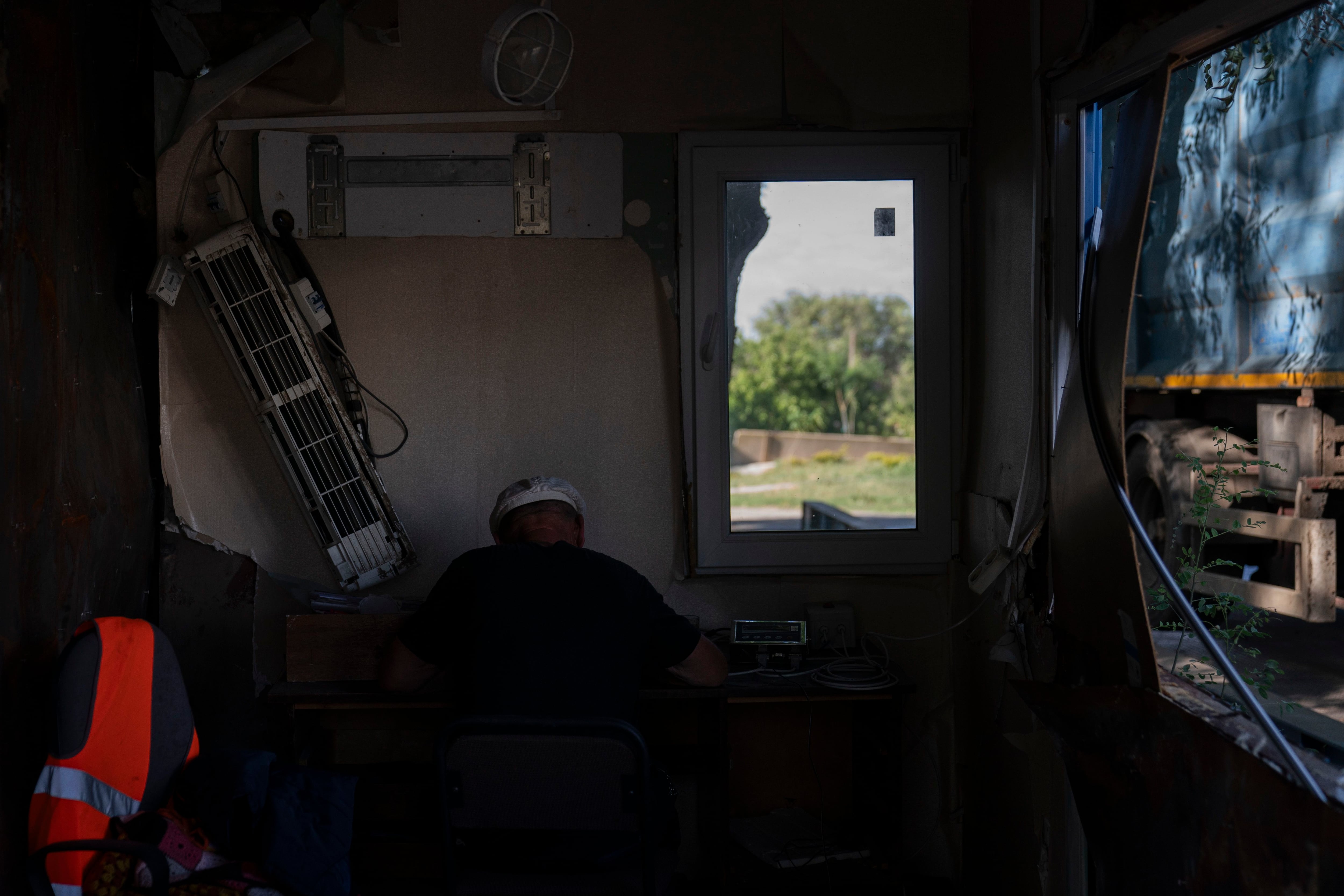 Un empleado trabaja en una oficina parcialmente dañada por los ataques con misiles rusos. (AP Foto/Jae C. Hong)