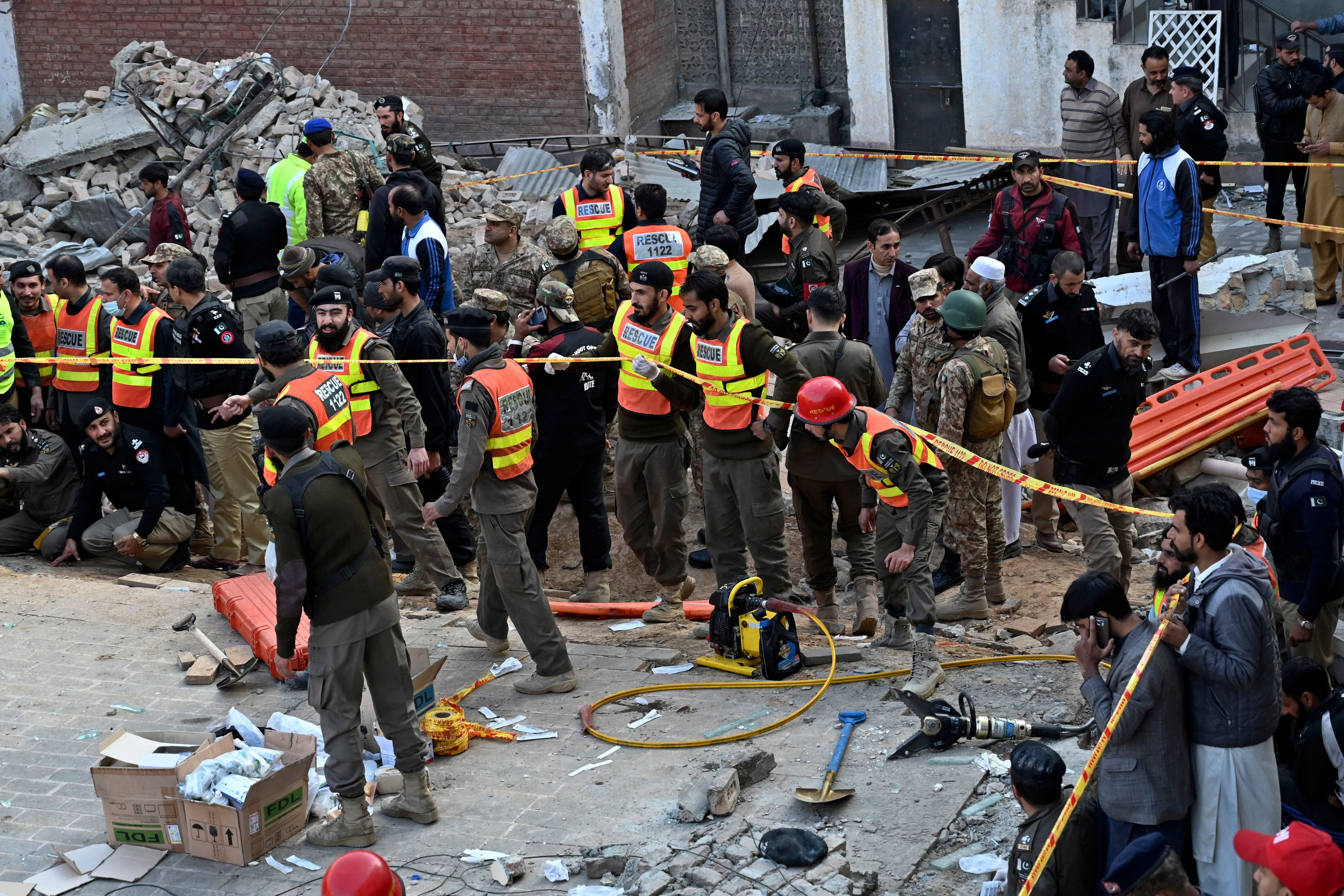 Funcionarios de seguridad y rescatistas en el sitio de un atentado suicida con explosivos dentro de una mezquita en la ciudad de Peshawar, Pakistán, el lunes 30 de enero de 2023. (AP Foto/Zubair Khan)