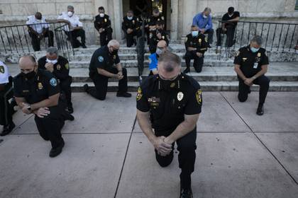 Oficiales arrodillados frente a la protesta en Coral Gables, Florida (AFP)