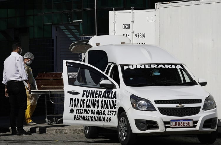 Un trabajador sanitario transporta un ataúd en el Hospital Evandro Freire de Río de Janeiro (REUTERS/Ricardo Moraes)