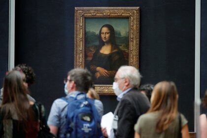 El público, con máscaras protectoras, se paran frente al cuadro "Mona Lisa" de Leonardo Da Vinci en el museo del Louvre (REUTERS / Charles Platiau)
