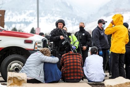 La policía acompaña a las personas evacuadas después de una llamada de un atacante en la tienda de comestibles King Soopers en Boulder, Colorado (Reuters)
