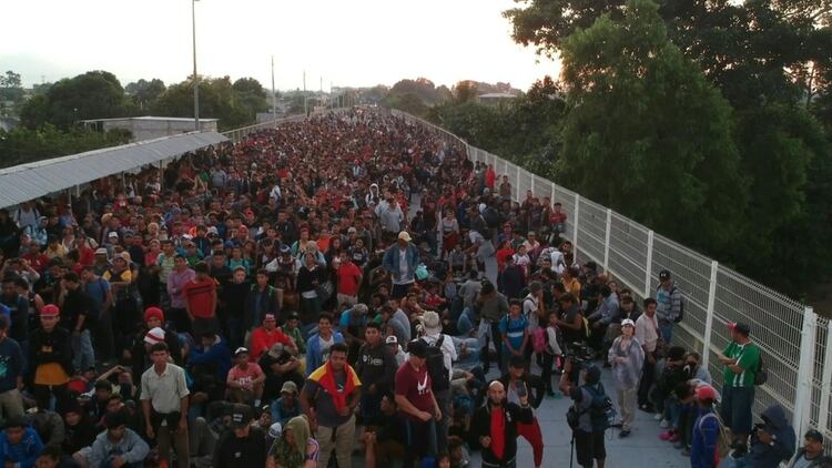 Cientos de migrantes centroamericanos que en caravana huyen de la pobreza y violencia, la mayoría hondureños, buscaban el lunes en un puente fronterizo entre Guatemala y México que las autoridades mexicanas les permitan el ingreso en masa para continuar a Estados Unidos.