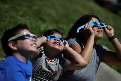 Chicos en Buenos Aires disfrutan del eclipse parcial de Sol - REUTERS/Agustin Marcarian