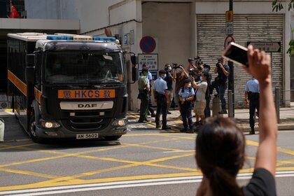 Una mujer hace un gesto hacia una camioneta del departamento de servicios penitenciarios, luego de que el activista Joshua Wong fuera sentenciado por participar en una asamblea no autorizada el 4 de junio de 2020, afuera del tribunal en Hong Kong, China, el 6 de mayo de 2021. REUTERS / Lam Yik