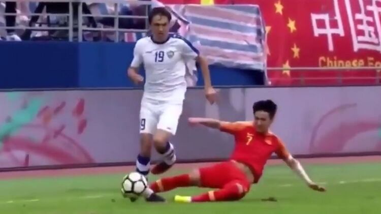 El momento de la patada de Wei Shihao al jugador de la selección de Uzbekistán que le provocaría la rotura de la tibia derecha