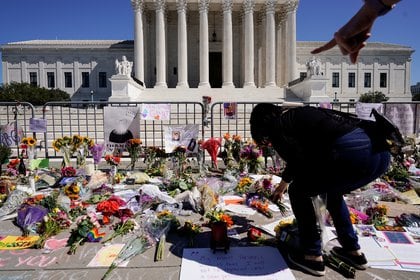 Mujer deposita flores frente al edificio de la Corte Suprema en Wahsington (Reuters)