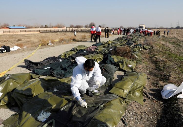 Cuerpos de pasajeros en bolsas de plástico en el sitio donde el avión de Ukraine International Airlines se estrelló después del despegue del aeropuerto iraní Imán Jomeini, en las afueras de Teherán. 8 de enero 2020. Nazanin Tabatabaee/WANA (West Asia News Agency) vía REUTERS. ATENCIÓN EDITORES - ESTA IMAGEN HA SIDO ENTREGADA POR UN TERCERO.