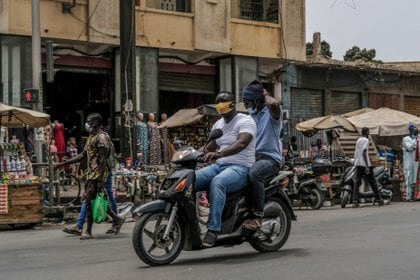 Dos hombres con mascarilla en una moto en Dakar (Europa Press) 