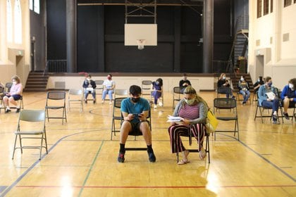 Gente sentada tras recibir su dosis de la vacuna contra el coronavirus en Pasadena, California. REUTERS/Lucy Nicholson