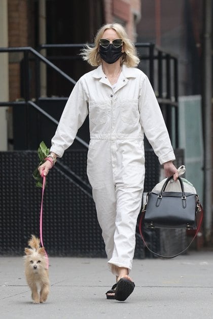 Naomi Watts lució un jumpsuit blanco mientras paseó a su perro por las calles de Tribeca, en Nueva York. Completó su outfit con cartera y sandalias negras, lentes de sol y tapabocas