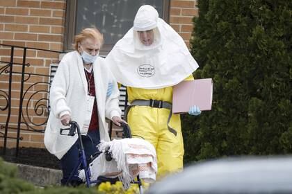 Médicos ayudan a un residente del hogar de ancianos St. Joseph a abordar un autobús, después de que varios residentes dieron positivo en la prueba de la enfermedad coronavirus (COVID-19) en Woodbridge, Nueva Jersey
