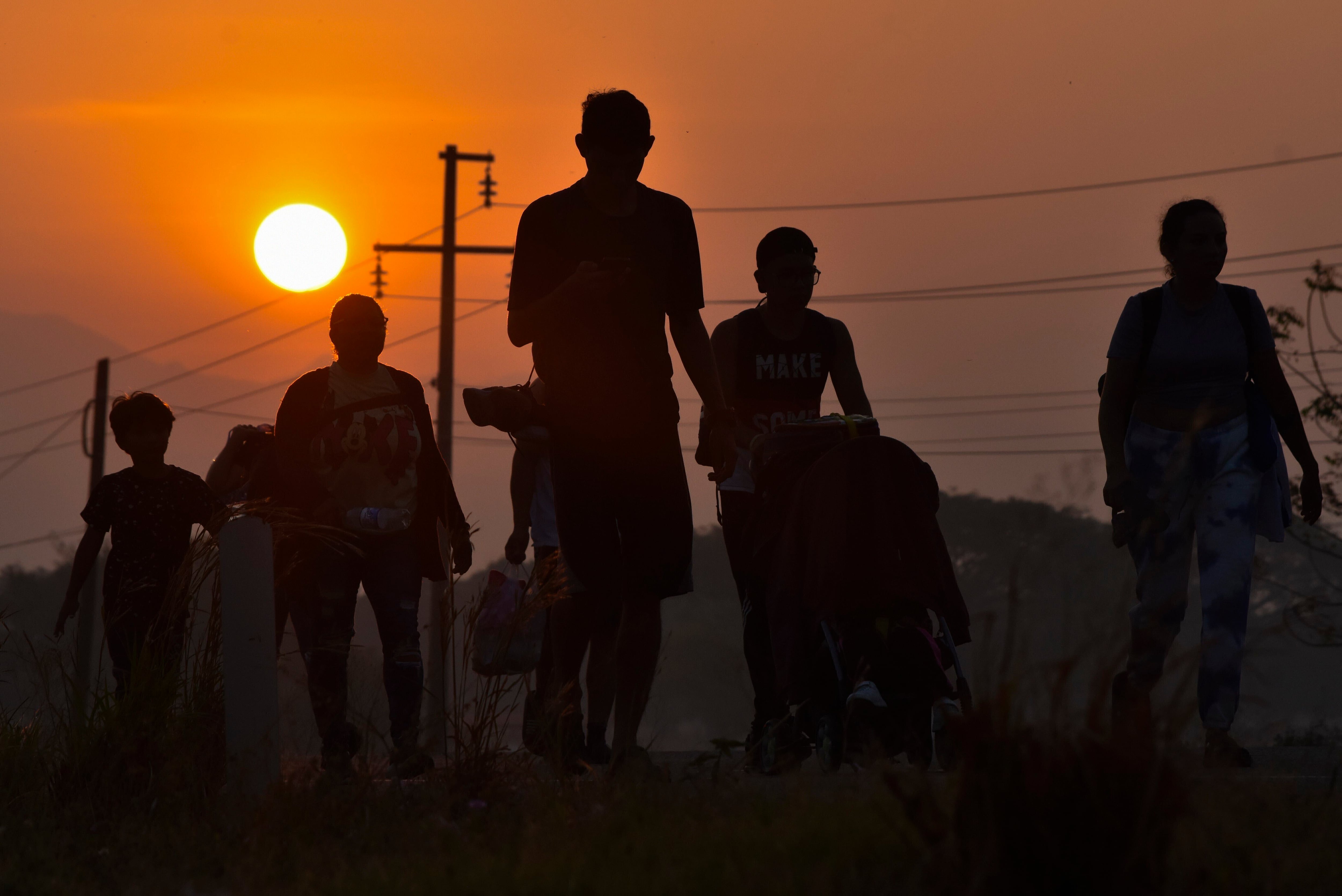 Migrantes caminan en el amanecer por una autopista hacia Arriaga, Chiapas, estado sureño de México, el lunes 8 de enero de 2024, en una caravana que se dirige hacia la frontera norte con Estados Unidos. (AP Foto/Édgar H. Clemente)