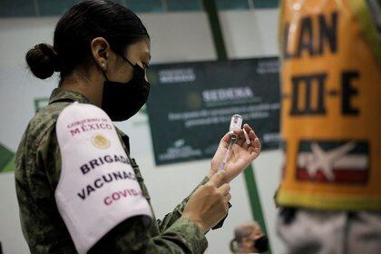 Una oficial del ejército prepara una dosis de la vacuna china CanSino en contra del COVID-19 durante una campaña masiva en la Universidad Autónoma de Nuevo León en San Nicolás de los Garza, a las afueras de Monterrey. México, 27 de abril de 2021/Daniel Becerril