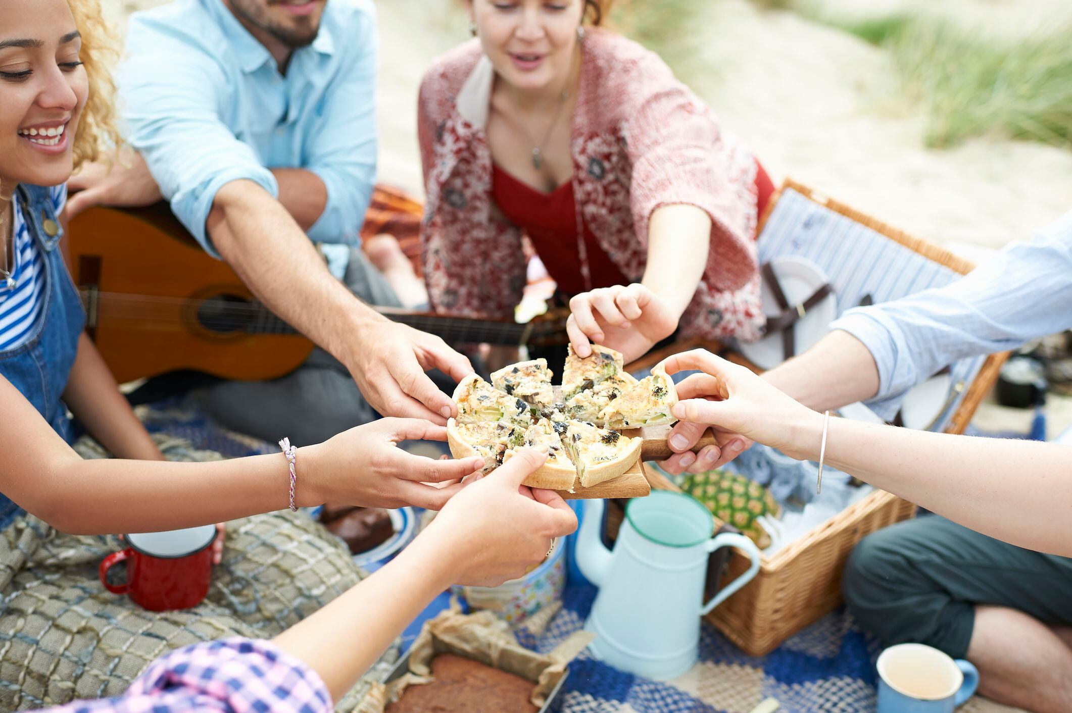 Amigos compartiendo comida en un picnic en la playa