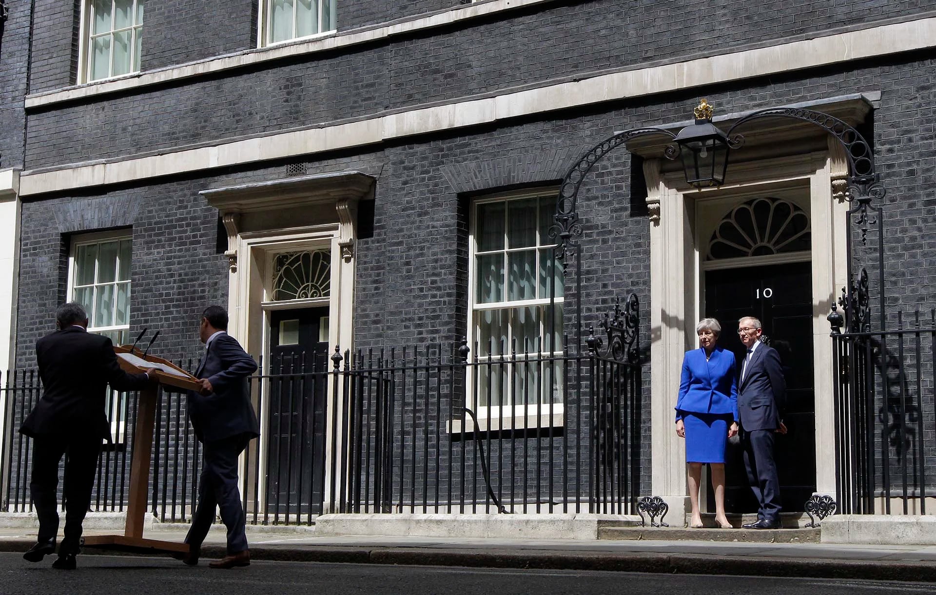 La premier británica, Theresa May, y su esposo, Philip, en la puerta de Downing Street tras dirigirse a la prensa este luego de la audiencia con la reina Isabel II en el Palacio de Buckingham