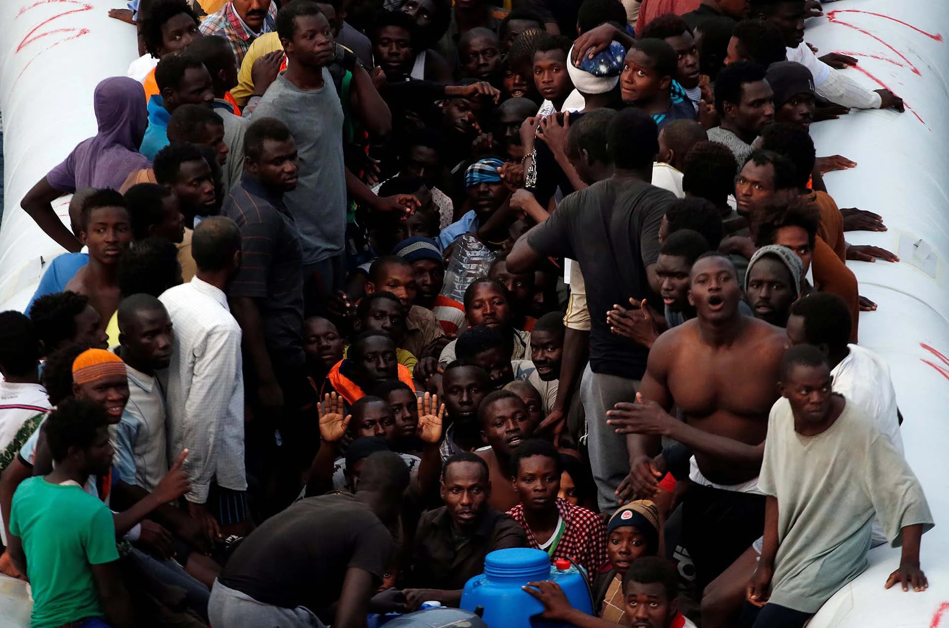 Un grupo de migrantes aguarda por la ayuda humanitaria de “Save The Children” en el Mediterráneo frente a las costas libias (REUTERS)