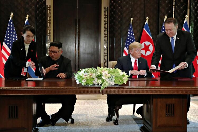 Kim Jong-un, acompañado de su hermana Kim Yo-jong, firma al declaración de Singapur junto a Donald Trump, acompañado por el Secretario de Estado Mike Pompeo (Reuters)