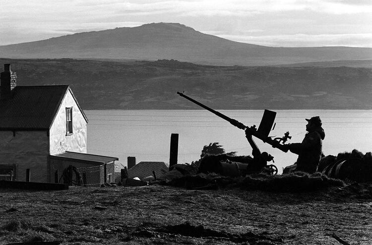 Está solo y espera. Lo acompañan una ametralladora antiaérea y un singular paisaje. La bahía está en calma. Los Harrier no tardarán en llegar (Foto: Telam).