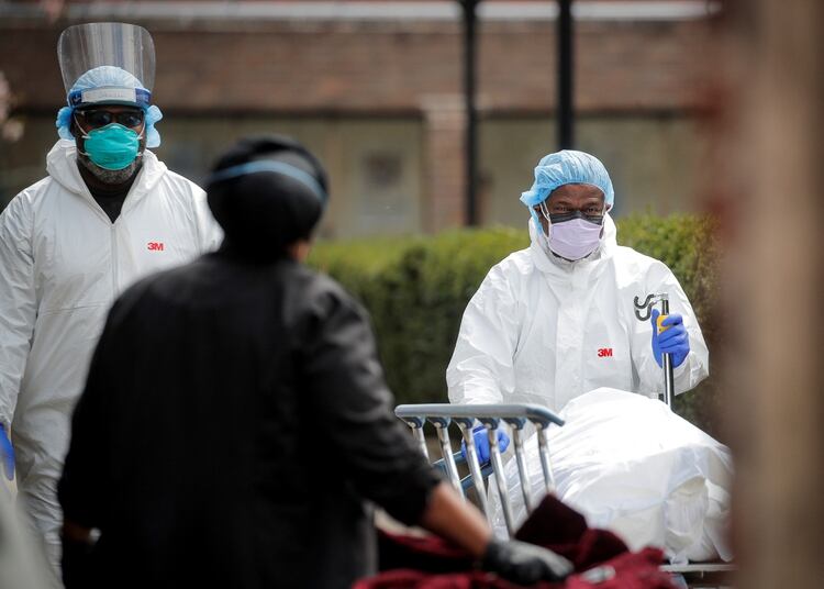 Trabajadores de la salud transportan a un cadáver en el Centro Judío de Ingsbrook en Brooklyn, Nueva York (REUTERS/Brendan McDermid)