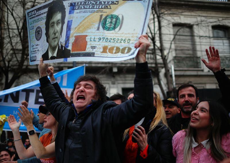 El candidato a presidente de La Libertad Avanza, con un gesto característico y una gigantografía de un dólar con su rostro. REUTERS/Agustin Marcarian