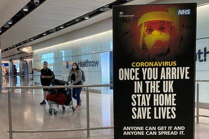 A public health campaign advert is seen as passengers arrive from international flights at Heathrow Airport, as the spread of the coronavirus disease (COVID-19) continues, in London, Britain, May 10, 2020.  REUTERS/Toby Melville