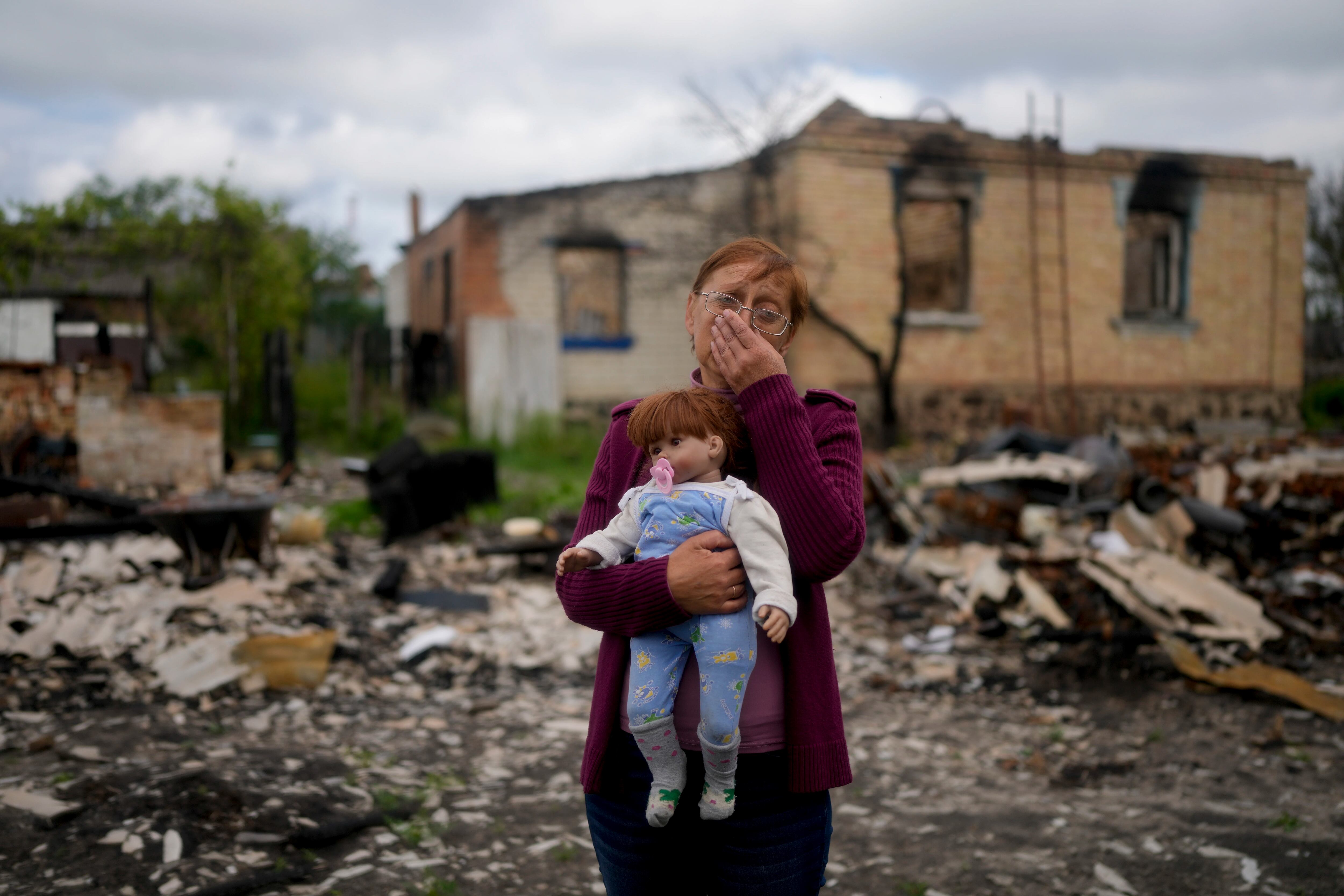Nila Zelinska sostiene una muñeca que pertenece a su nieta, que pudo encontrar en su casa destruida en las afueras de Potashnya, Kiev, Ucrania, el martes 31 de mayo de 2022. Zelinska acaba de regresar a su ciudad natal después de escapar de la guerra y descubrir que no tiene hogar.