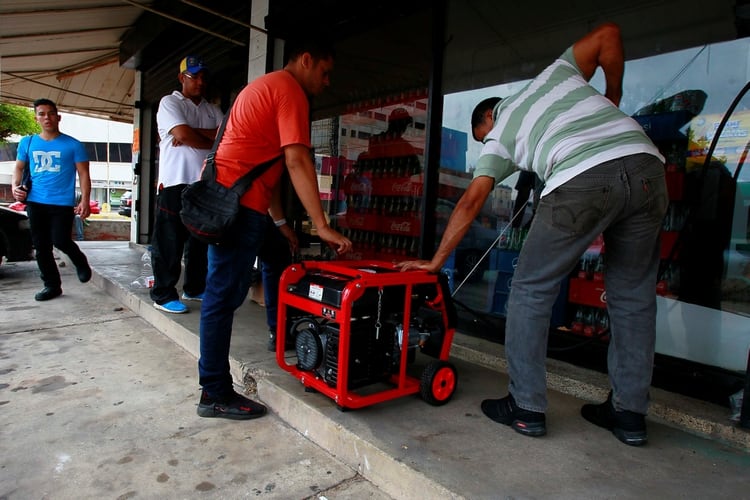 Ciudadanos encienden un generador eléctrico en un supermercado en Maracaibo (Reuters)