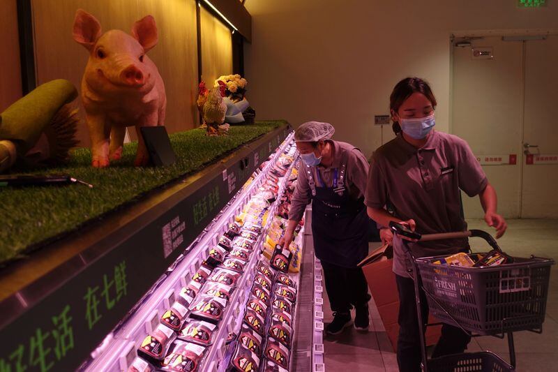 Una repositora en un supermercado en China, que está supliendo con carne vacuna su faltante de carne porcina.  REUTERS/Tingshu Wang