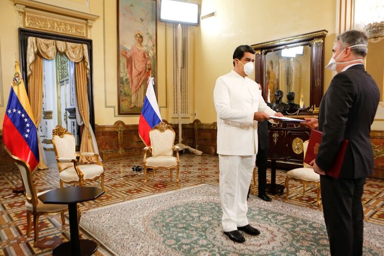 El dictador de Venezuela, Nicolás Maduro, entrega las credenciales al embajador de Rusia en Venezuela, Sergey Melik-Bagdasarov, ambos con máscaras debido al brote de la enfermedad del coronavirus en el Palacio de Miraflores en Caracas (Reuters)