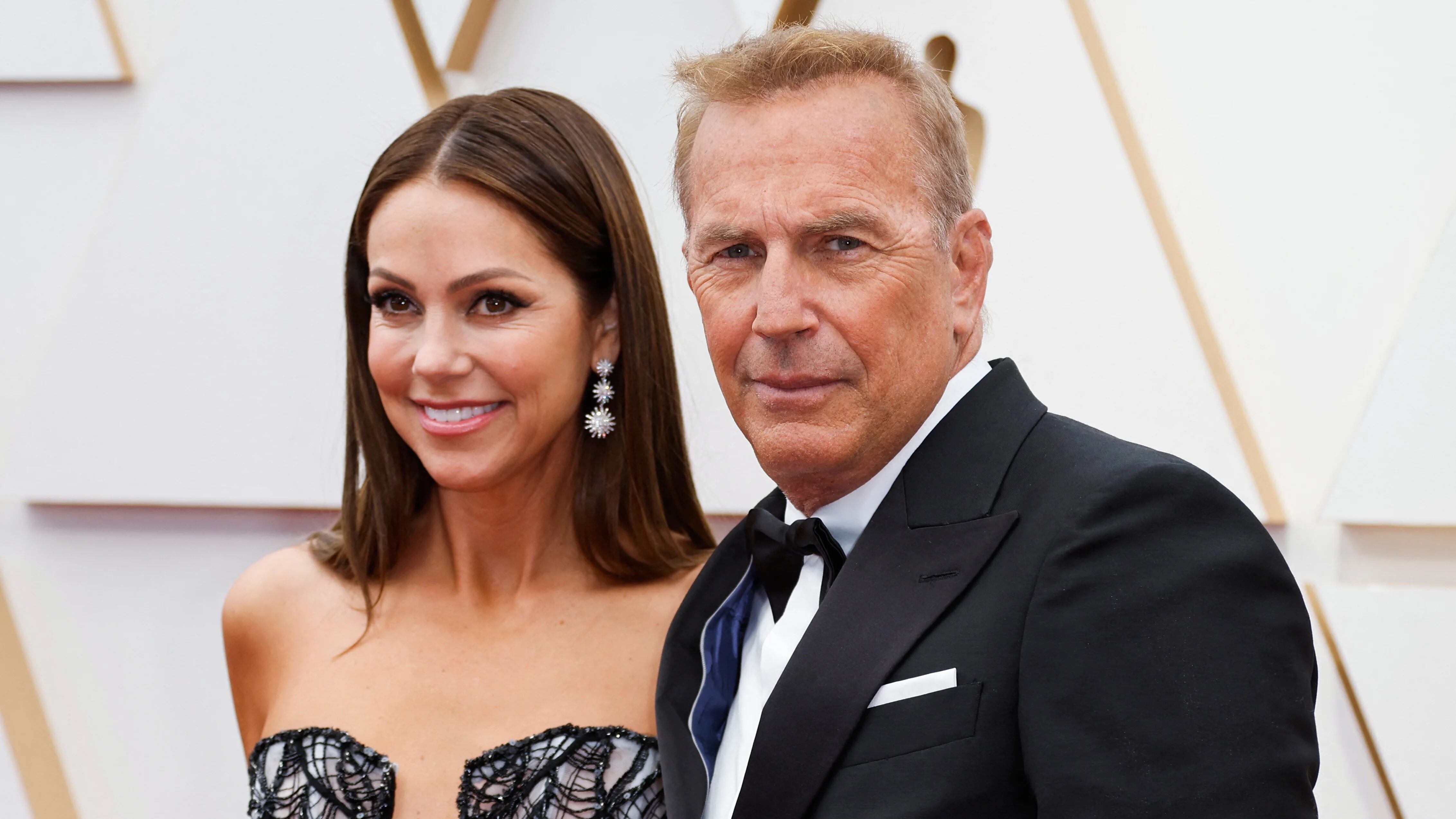 Kevin Costner and wife Christine Baumgartner pose on the red carpet during the Oscars arrivals at the 94th Academy Awards in Hollywood, Los Angeles, California, U.S., March 27, 2022. REUTERS/Eric Gaillard