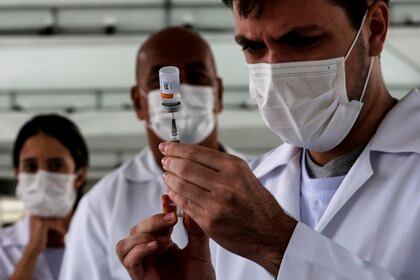 Un trabajador de la salud prepara una dosis de la vacuna Sinovac hoy, en un centro de vacunación instalado en la "Pasarela de Samba", en Río de Janeiro (Brasil). EFE/ Antonio Lacerda