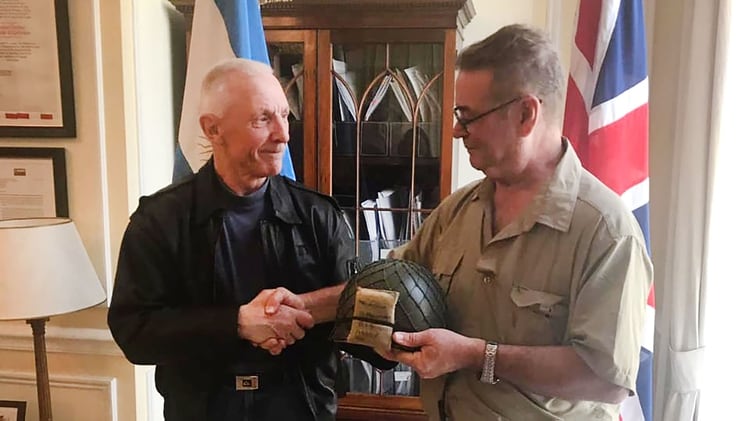 John Curd y Jorge Melinchuk en la embajada argentina en Londres. El veterano inglÃ©s le devolviÃ³ el casco que se habÃ­a llevado de las islas como recuerdo de guerra