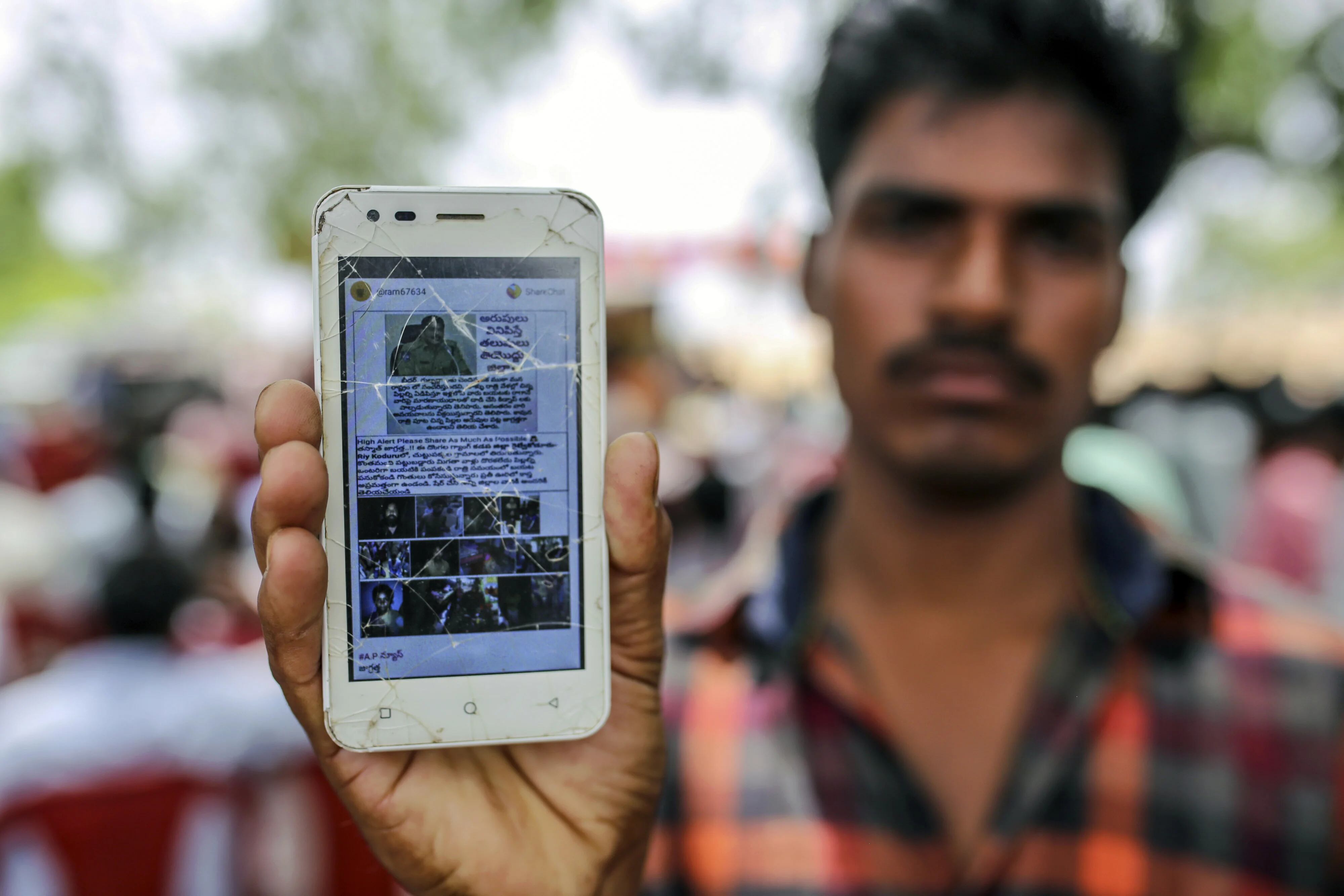 Un hombre muestra la pantalla de su teléfono celular con un mensaje falso difundido a través de WhatsApp (Bloomberg / Dhiraj Singh)