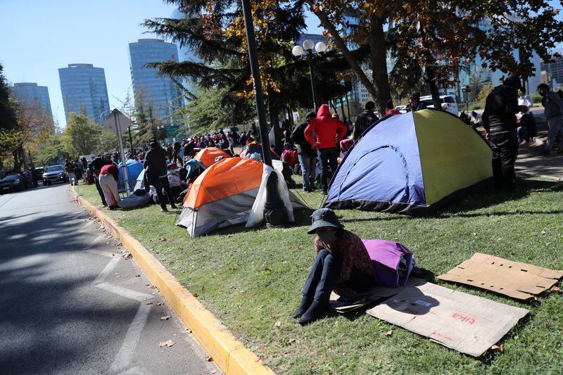Ciudadanos bolivianos permanecen instalados en las afueras del consulado de su país en Santiago, Chile. el 28 de abril (REUTERS/Iván Alvarado)