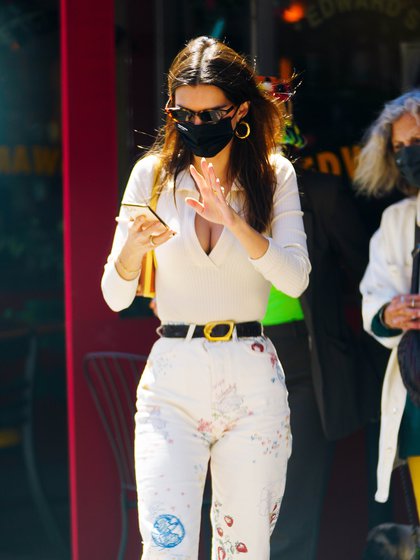 Emily Ratajkowski disfrutó de un día de sol para pasear por las calles de Nueva York. La modelo lució un pantalón tiro alto con detalles estampados, un sweater blanco y un cinturón negro que combinó con su tapabocas. Además, llevó lentes de sol animal print