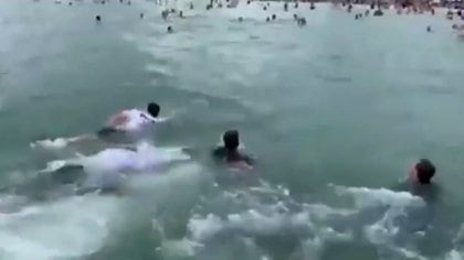 Bolsonaro nadando hacia decenas de personas