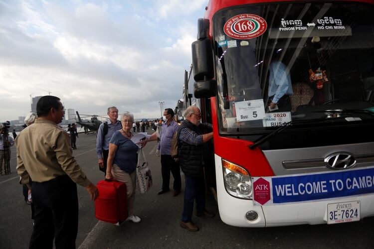 Los pasajeros se suben a un autobús que los llevó a la ciudad (REUTERS/Stringer)